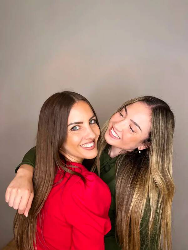Las dos hermanas de Bela, sonriendo juntas en el estudio