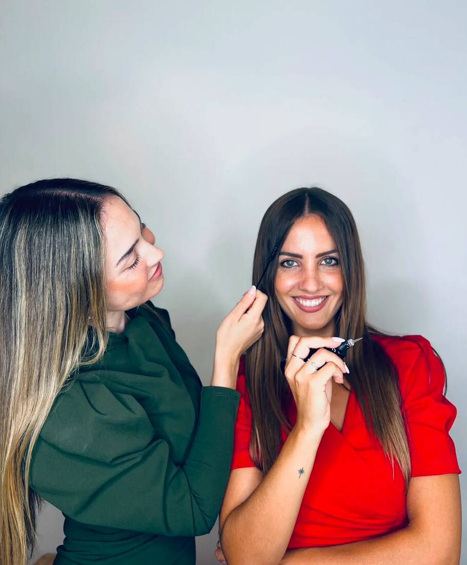Una de las hermanas de Bela revisando las cejas de su hermana en el estudio
